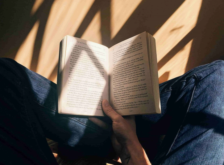 Человек читает книгу при солнечном свете